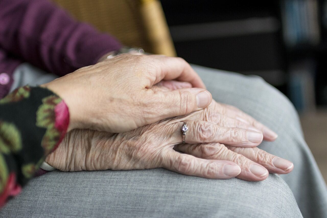 A nurse comforting an elderly resident at the bedside